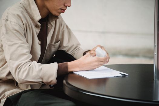 一个年轻人正坐在桌旁，专心准备学术作业的文件