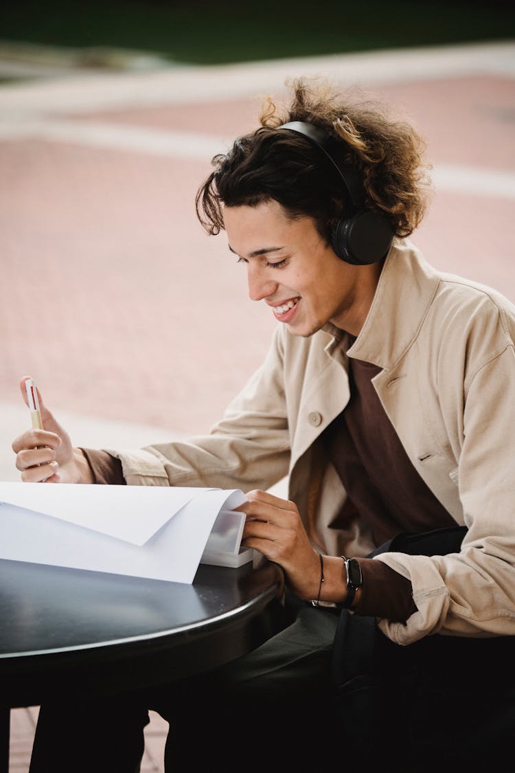 Smiling Man Reading Documents At Table In Park