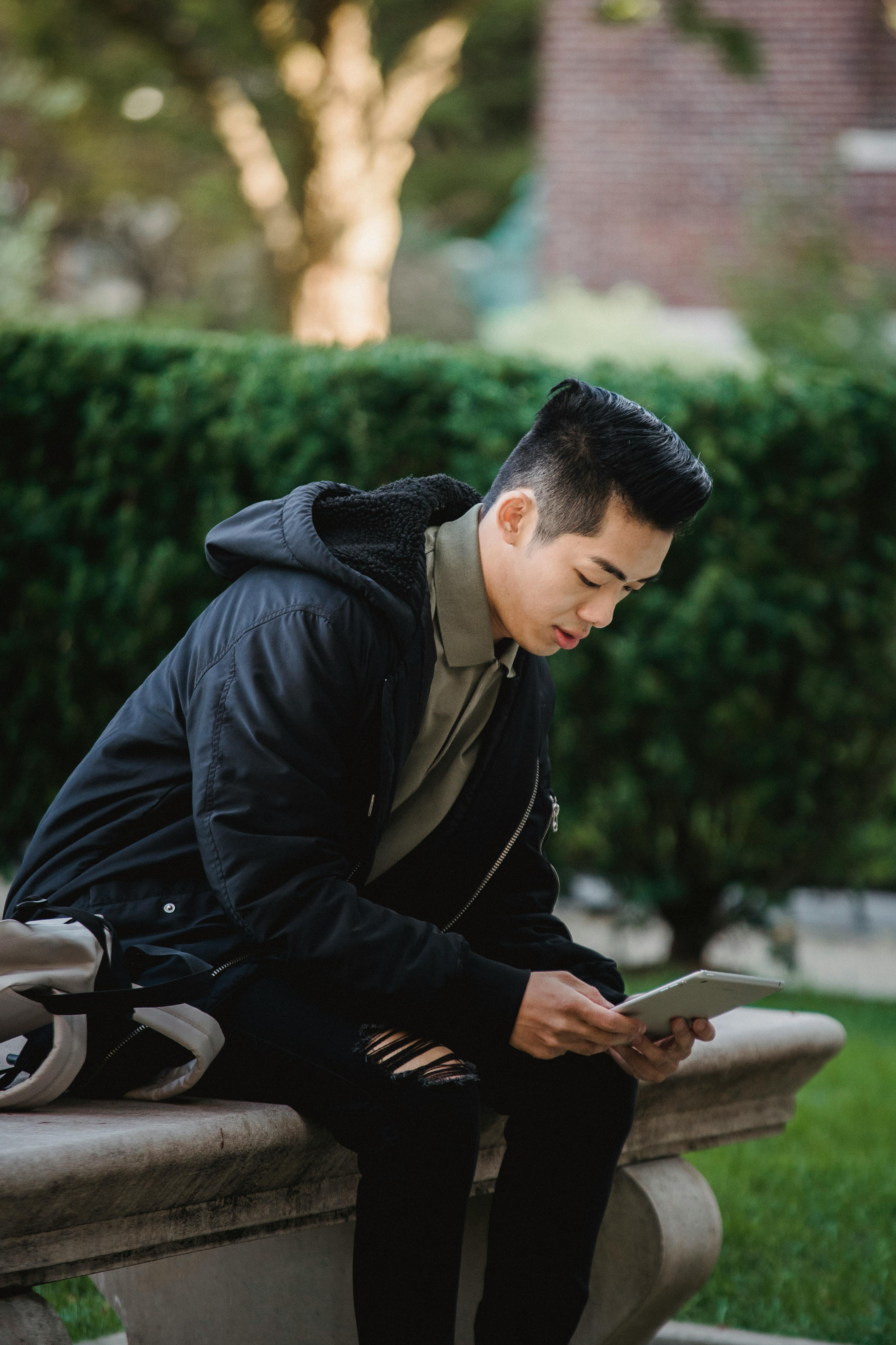 focused ethnic man using tablet