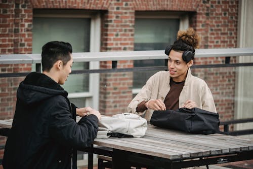 Free Diverse friends at table with backpacks Stock Photo