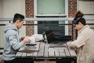 侧视图：一群年轻、专注的多种族学生身着休闲装，围坐在桌旁共同进行项目