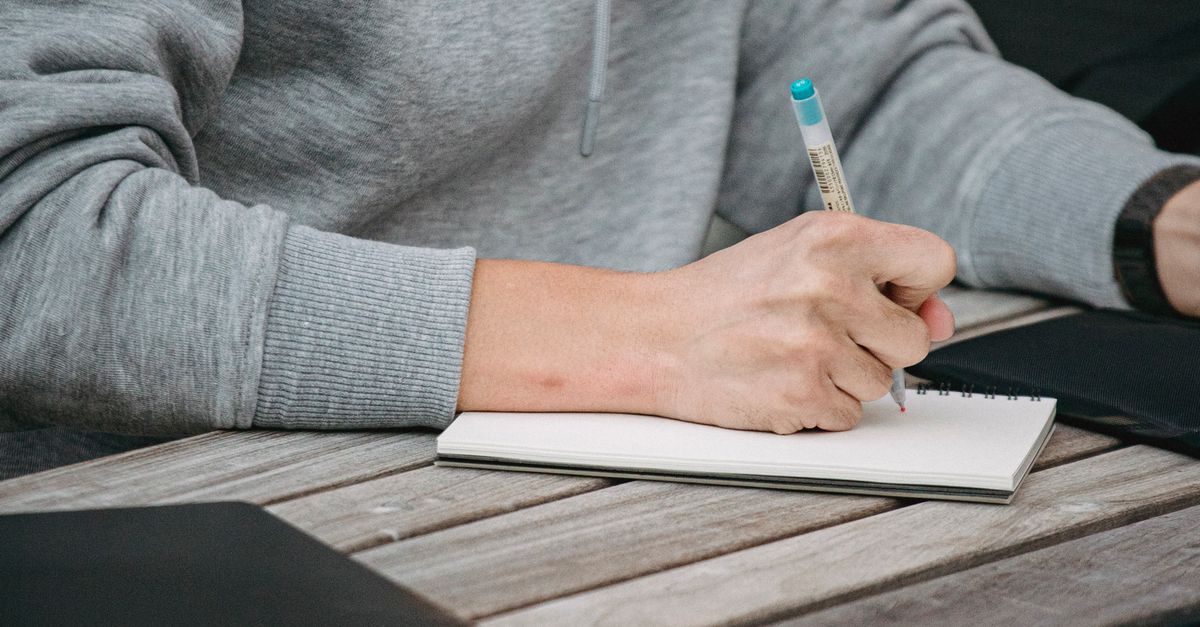 Taking Notes Notepad Concentrated man taking notes in notepad · Free Stock Photo