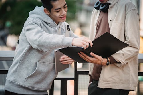 Free Cheerful multiethnic men looking at documents Stock Photo