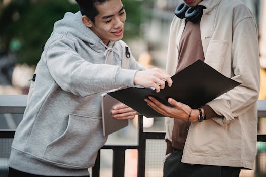 Two young men discussing a project outdoors, engaged and collaborating enthusiastically.