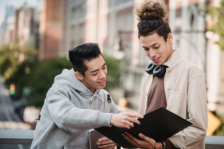 Cheerful Diverse Students Looking At Documents