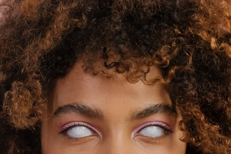 Woman With Brown Curly Hair And White Eyes