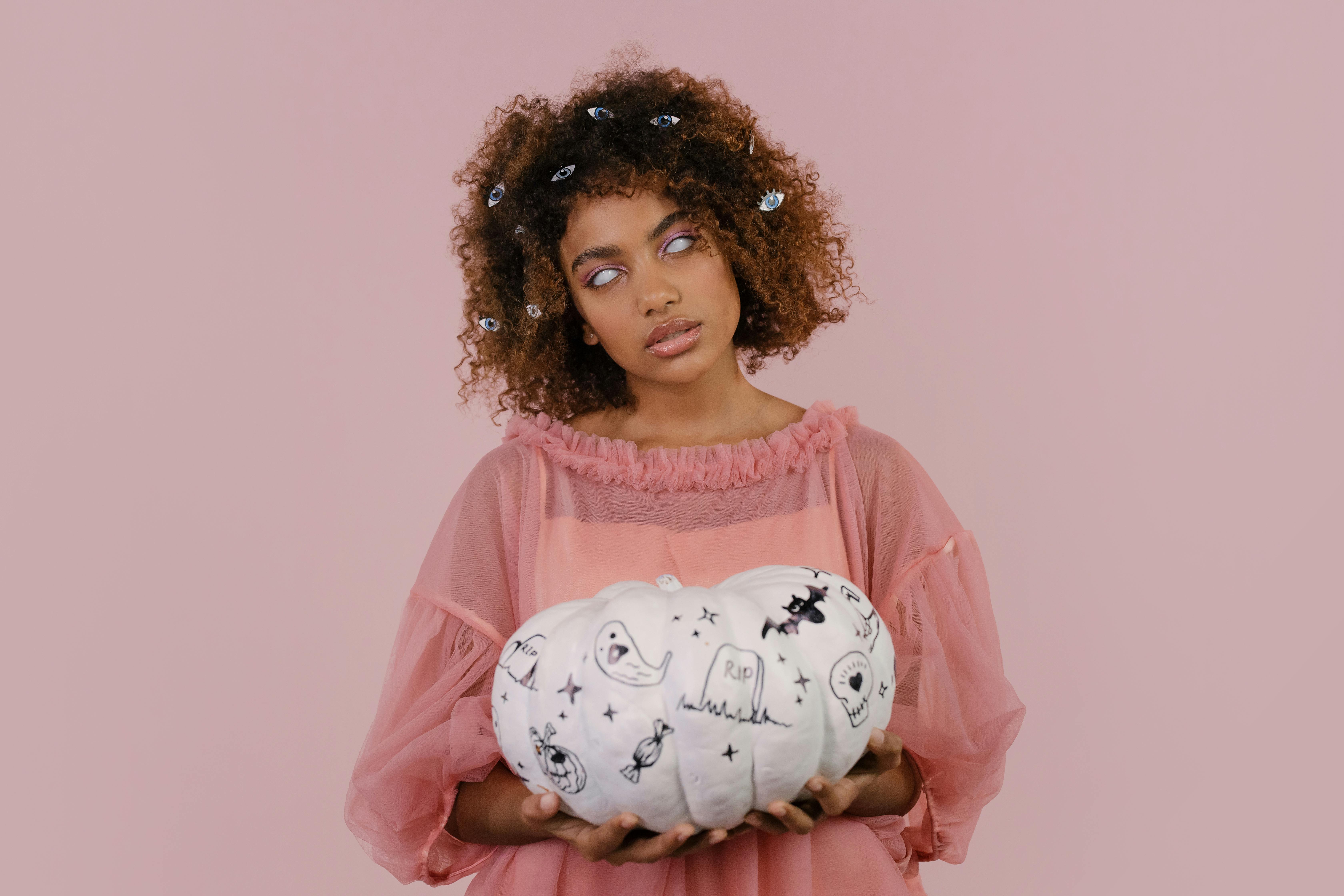 a blind woman holding a white pumpkin