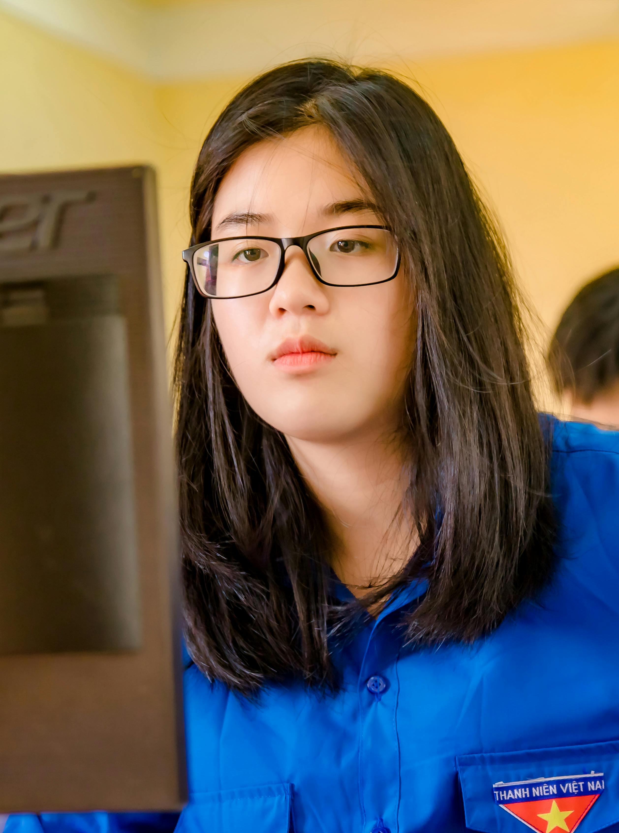Young woman in glasses concentrating on work at her computer indoors.