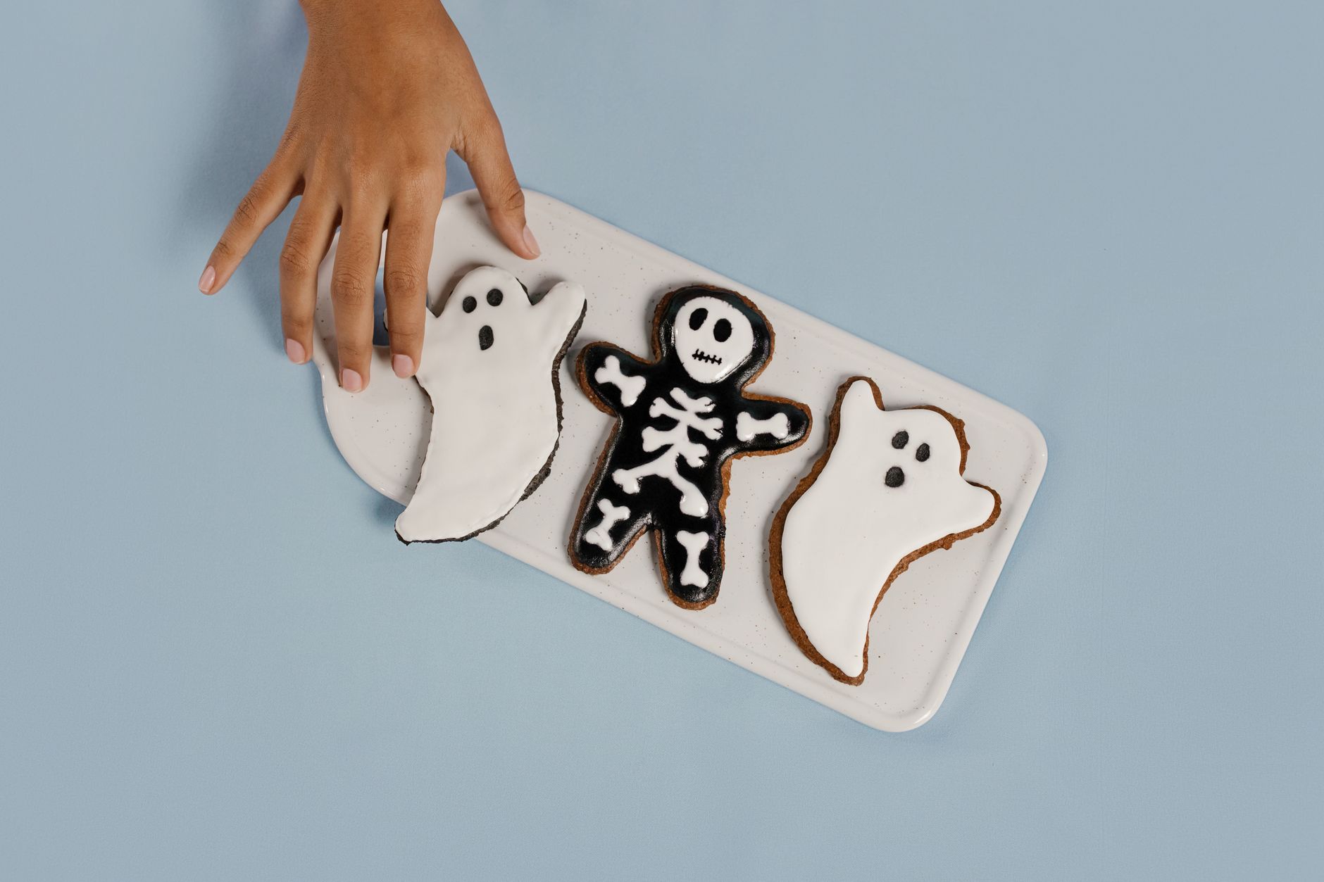 White chocolate being spread over ghost shaped rice treats