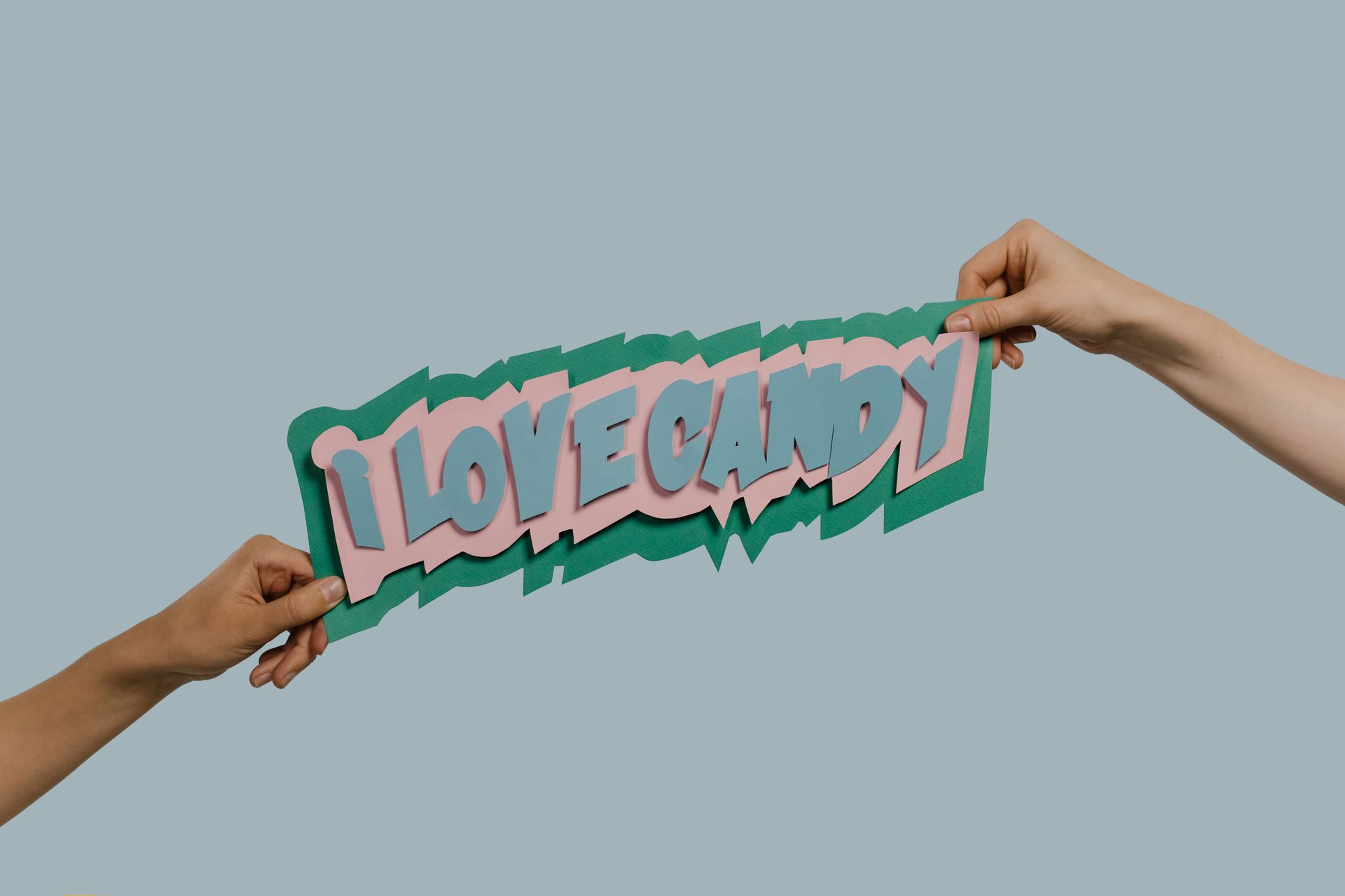 People Holding a Paper Cutout Words