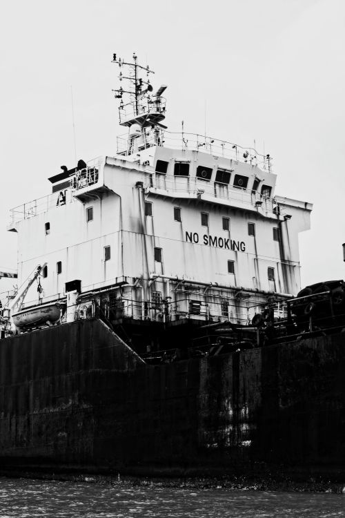 Free Black and white of tall old weathered shabby rusted merchant ship near coast of reservoir in daytime Stock Photo