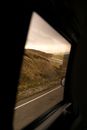 Dry hills and road through car window