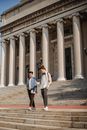 两名年轻人走下哥伦比亚大学的台阶，展现校园生活与教育主题