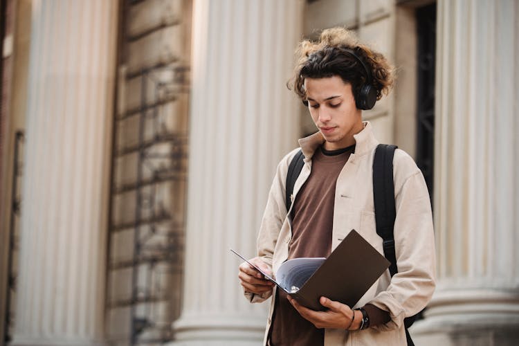 Serious Student Reading Documents In Folder