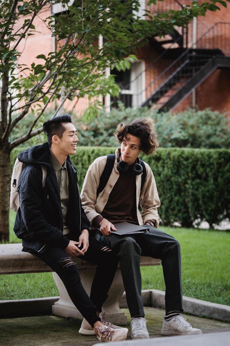 Asian Man Smiling Brightly While Talking To Friend