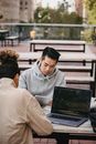 Focused diverse friends working at table with laptop