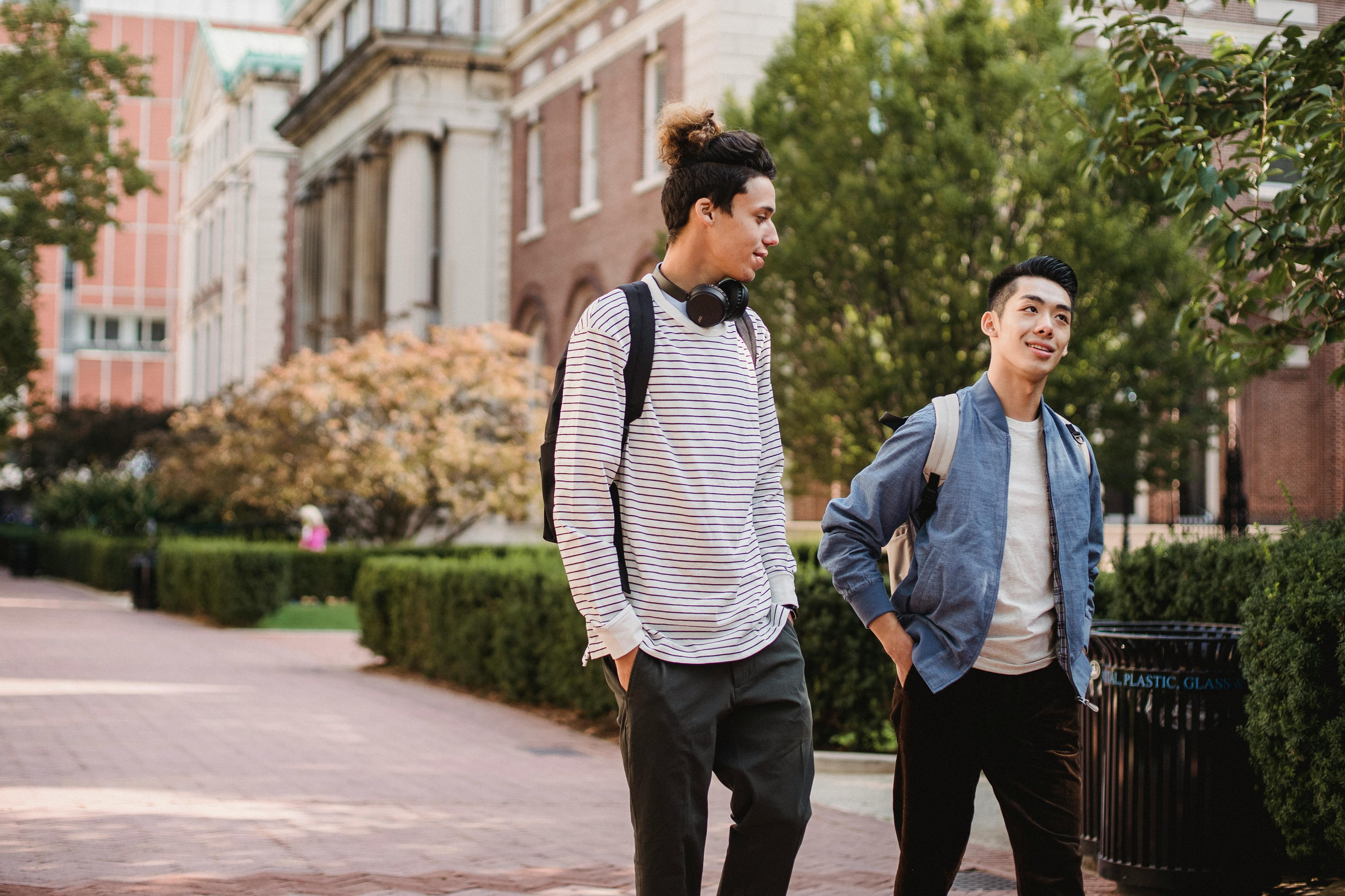 multiracial male friends talking while strolling in street