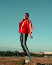A Man in Red Jacket and Black Jogging Pants