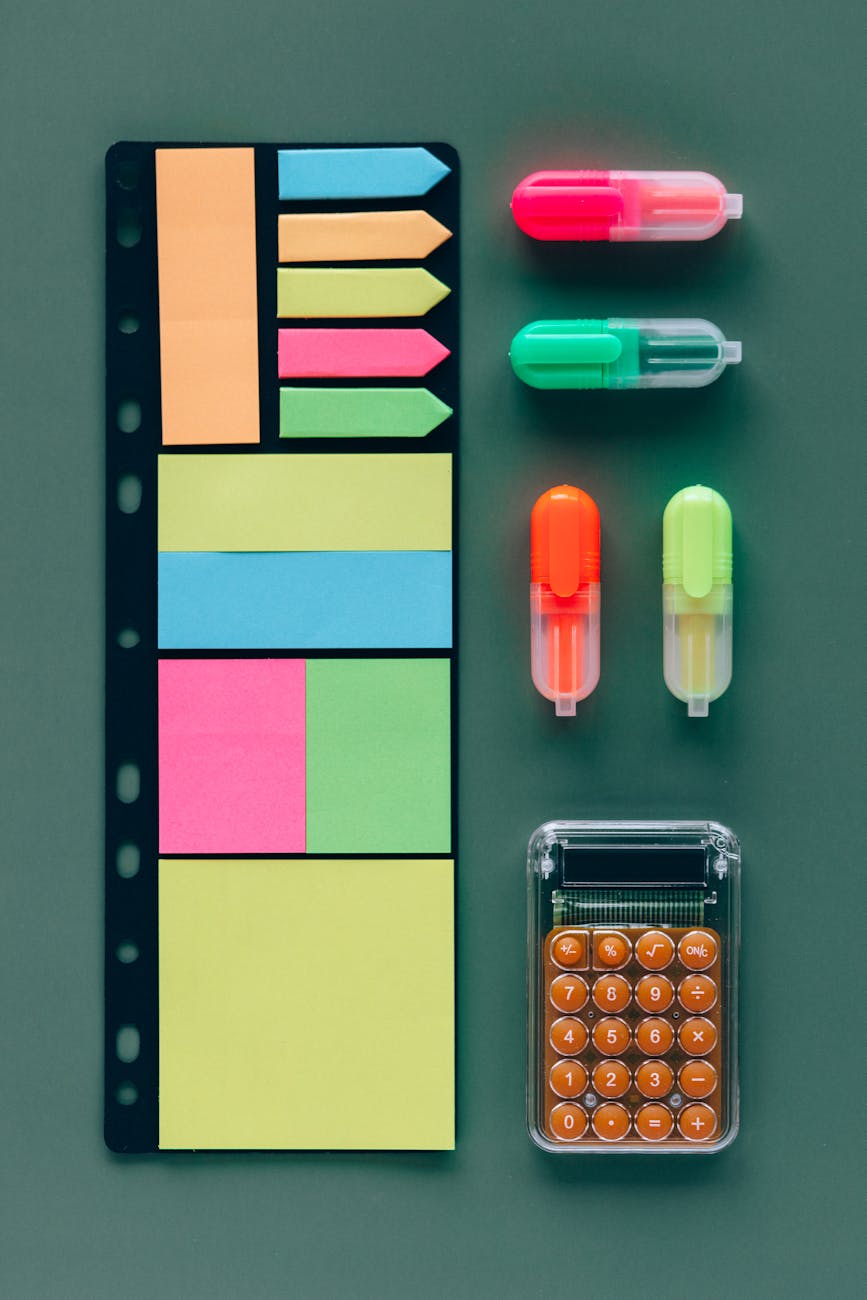 Highlighters Beside Sticky Notes and a Calculator