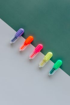 绿白背景上平铺着五支彩色荧光笔