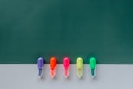 一系列色彩缤纷的荧光笔，以极简的绿色为背景，非常适合创意项目