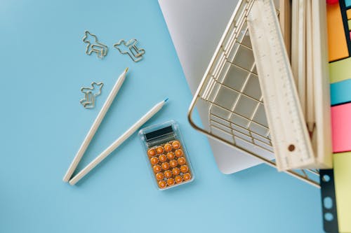 Orange Calculator Beside a Laptop 