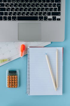Image of a neat workspace with a laptop, calendar, and stationery items.