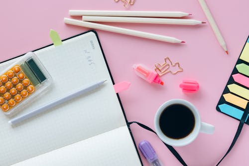 Free Pink Pen on White Notebook Beside White Ceramic Mug Stock Photo