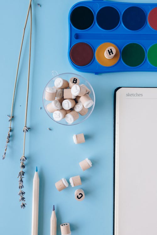 Lettered Erasers Beside a Watercolor Case