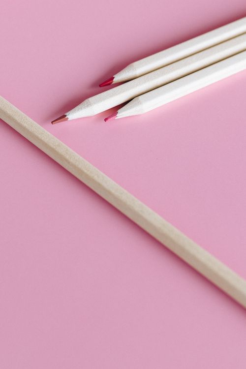 Free Close-up of white colored pencils with red tips on a pink background, minimal design. Stock Photo