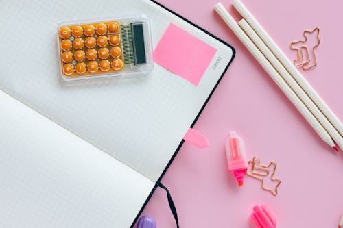 Pink Sticky Note on Open Notebook 