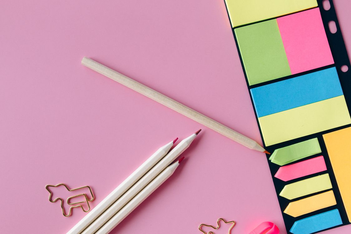 Colored Pencils and Sticky Notes on Pink Surface · Free Stock Photo