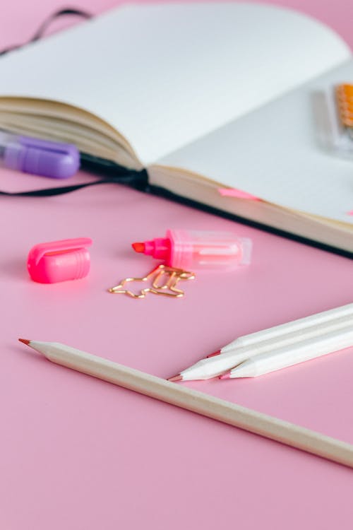 Pink Pencil Beside Pink Pencil on White Printer Paper