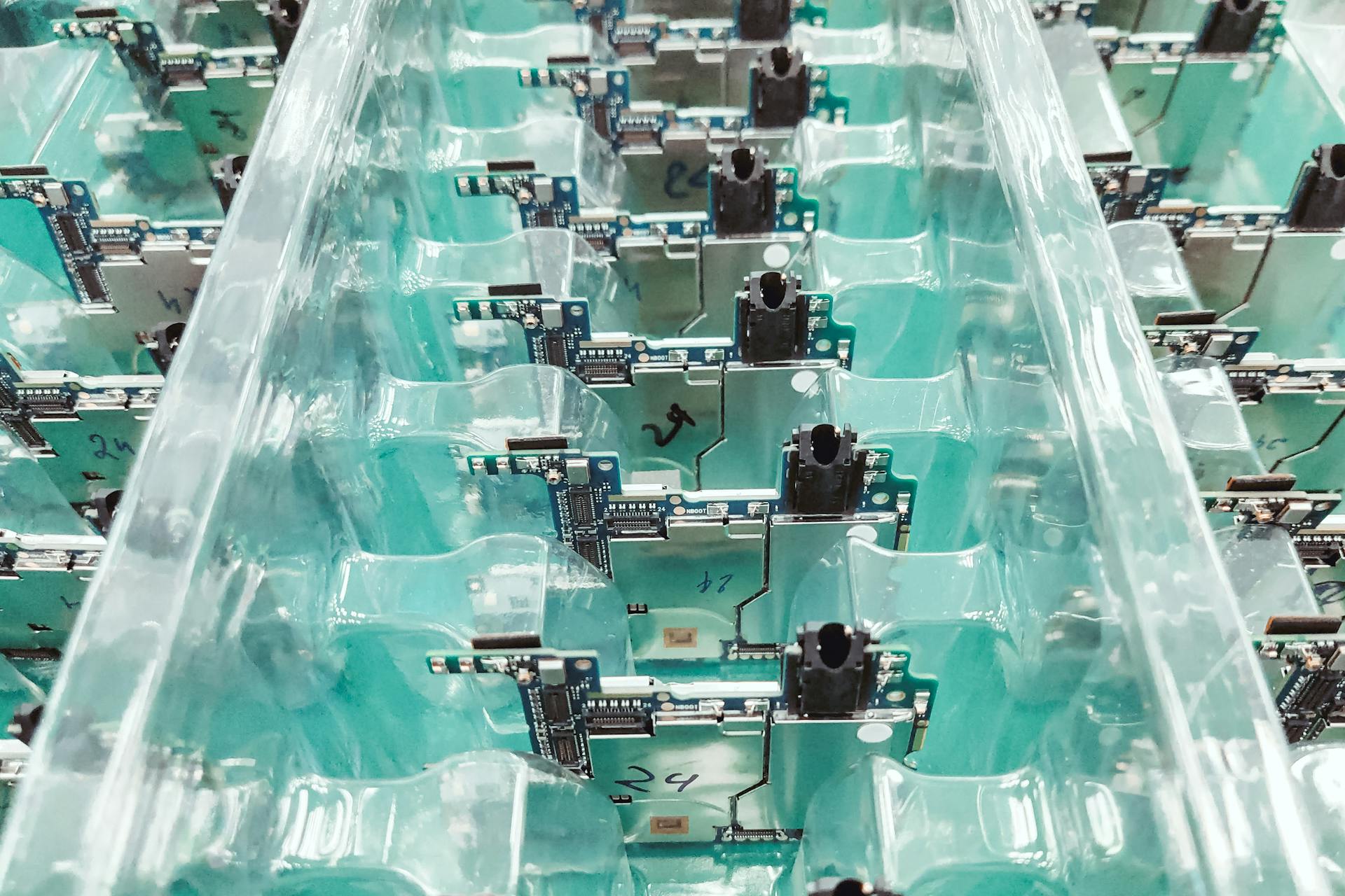 Detailed view of organized electronic circuit boards in a production setting.