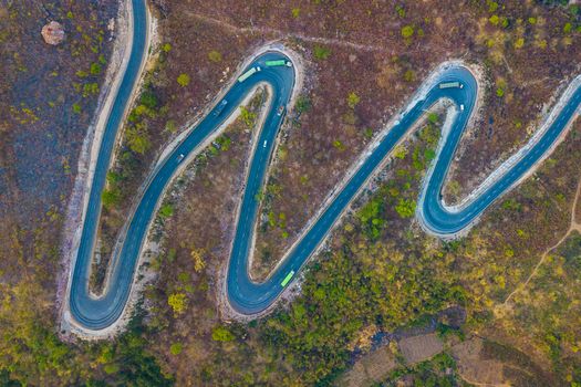 Stunning aerial shot of a winding road through a mountainous landscape.