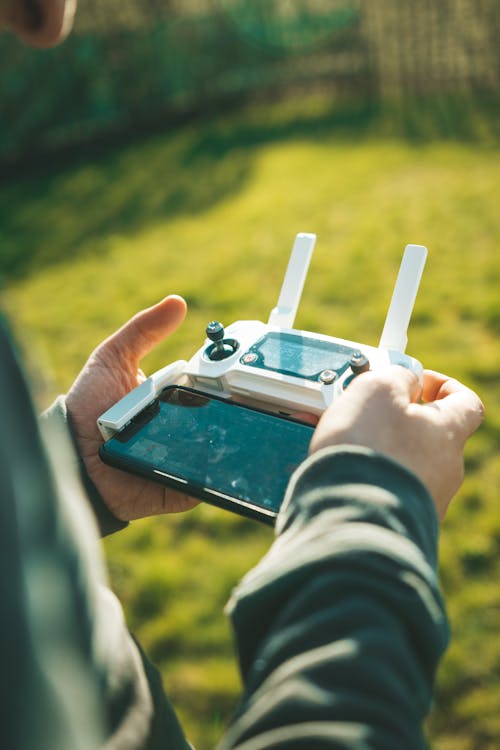 Person Holding White Drone Controller