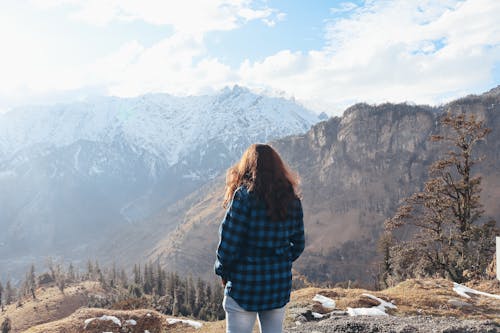 Unrecognizable woman standing on mountain peak