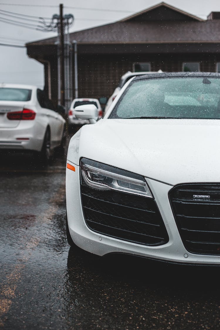 Modern White Car On Road Near House In Rainy Weather