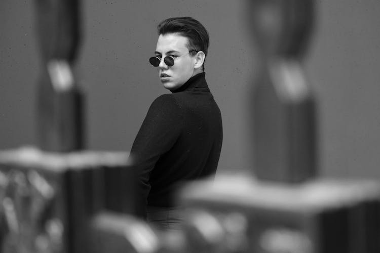 Stylish Man Standing Behind Fence On Street