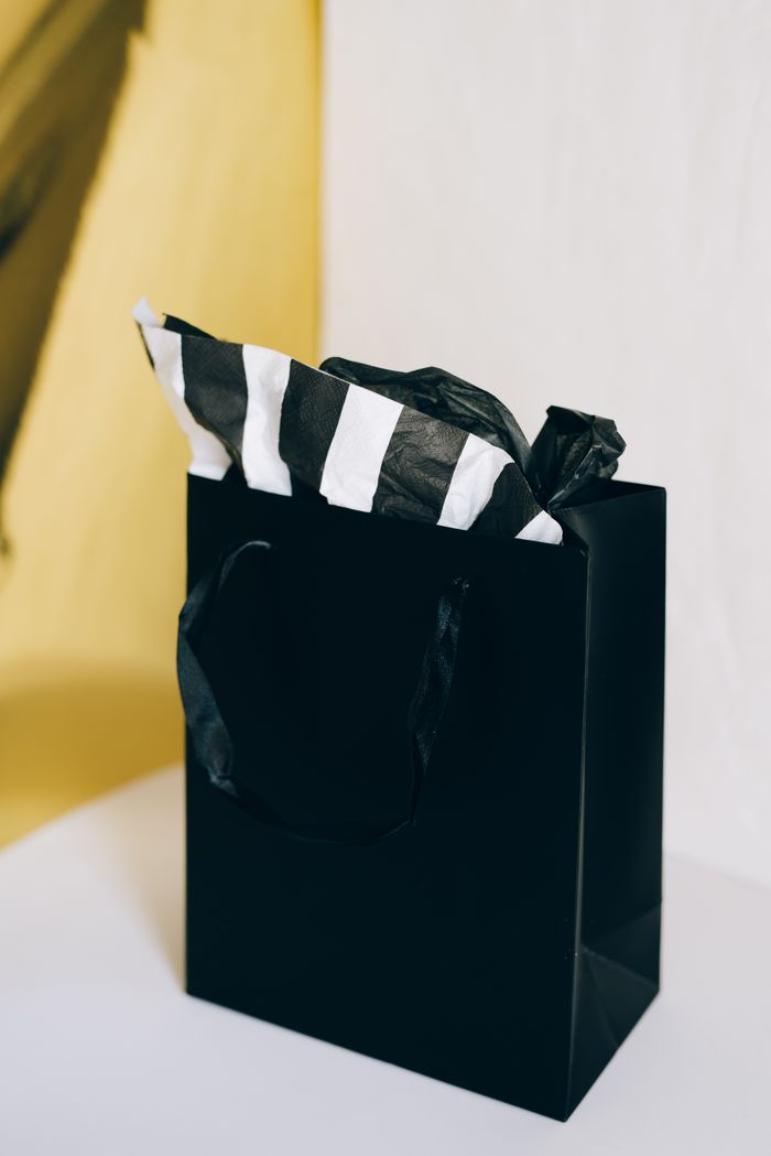 Black gift bag with striped tissue paper — photo by Leeloo The First on Pexels