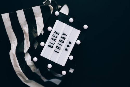Free Minimalist Black Friday sign with striped paper on a dark background, ideal for promotions. Stock Photo