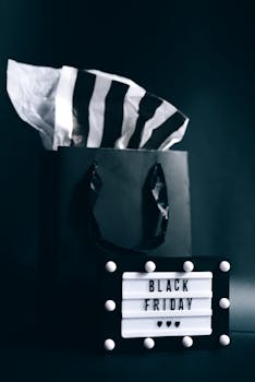 A stylish image of a black shopping bag with Black Friday lightbox sign against a dark background.