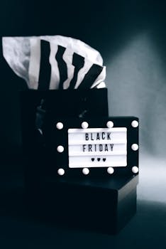 Stylish black gift box with 'Black Friday' lightbox sign, perfect for sale promotions.