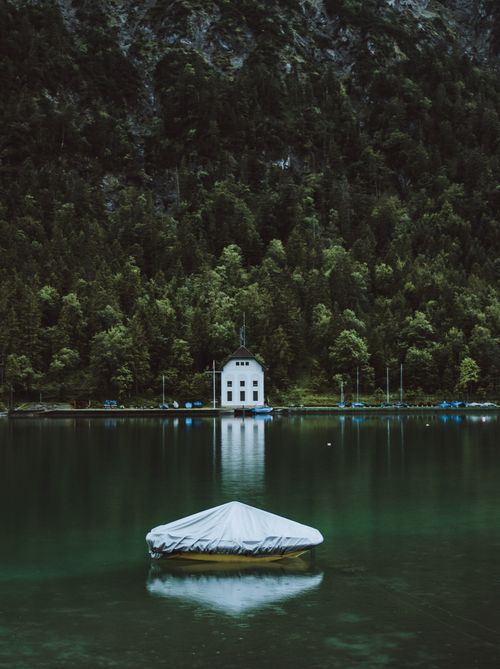 Free Serene landscape of a house reflecting on a misty lake in Tyrol, Austria. Stock Photo