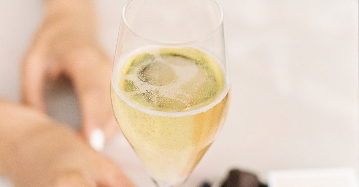 A glass of red wine and a plate of paella with seafood and rice on a wooden table.