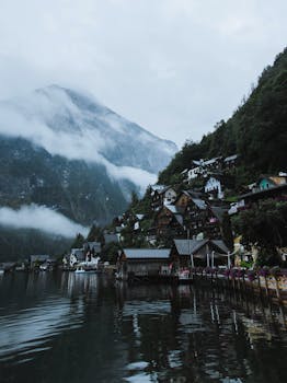 Picturesque Hallstatt village by the tranquil lake with misty mountains in Austria.