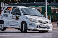 Faceless rider in vintage car on race