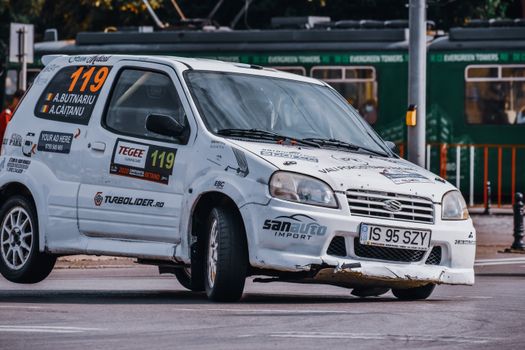 Unrecognizable person driving retro sport car on asphalt track during race in city