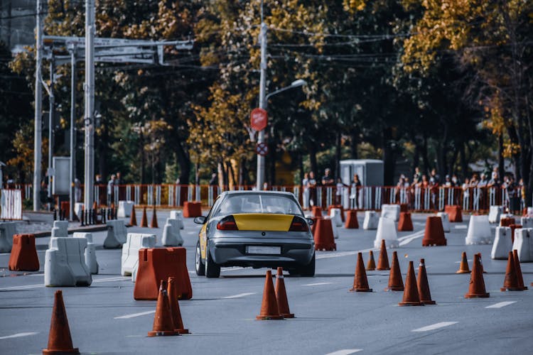 Yellow Grey Car Driving Through Traffic Cones In City