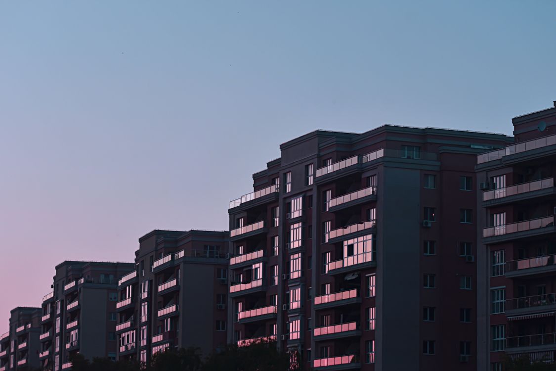 Facades of residential buildings with modern glass balconies at sunset ...